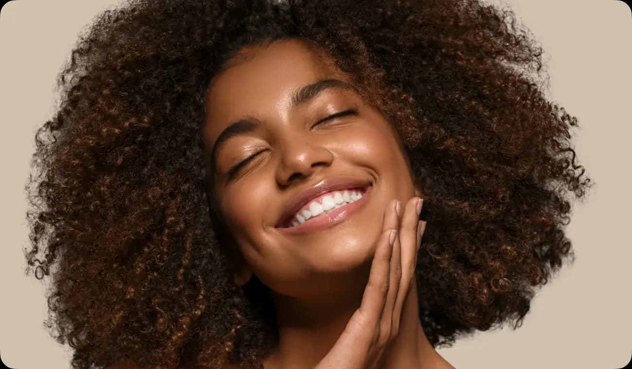 Woman smiling and touching her face