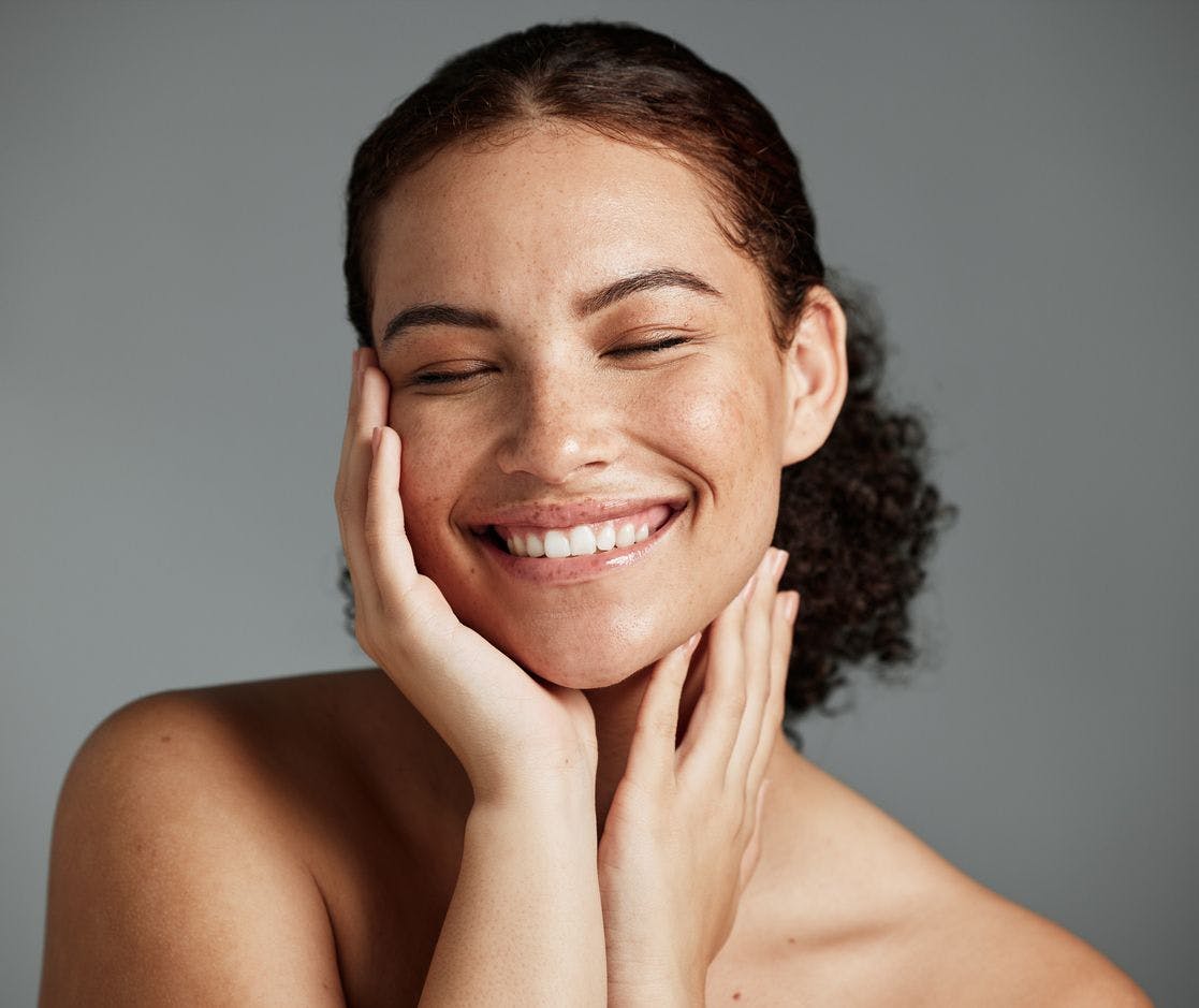 Woman smiling and satisfied with her chiseled jawline 
